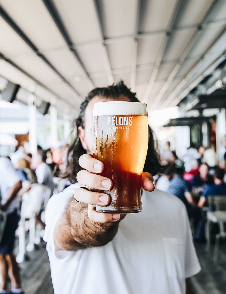 Man holding pint of Felons beer